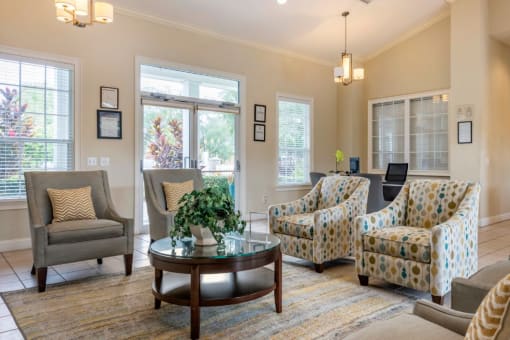 Clubhouse lounge with chairs, coffee table, rug, and pendant lighting