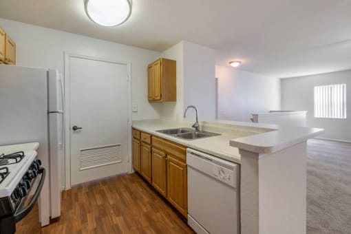 Kitchen with hardwood style flooring, double basin sink, and breakfast bar