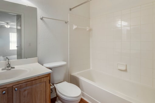 Bathroom with large mirror, vanity lighting, and tiled shower