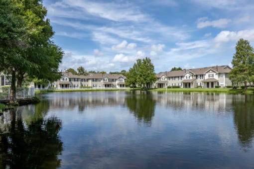 Apartment building exterior surrounded by native landscaping overlooking lake