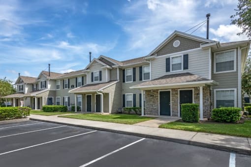 Apartment building exterior surrounded by native landscaping overlooking parking lot