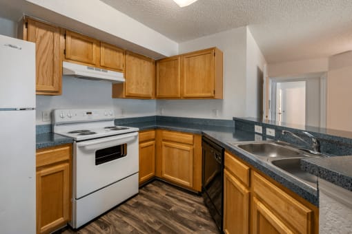 Kitchen with white appliances, hardwood style flooring, and double basin sink