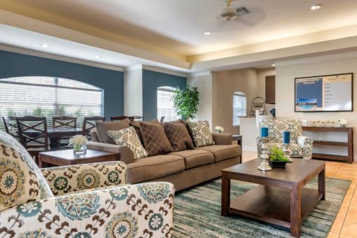 Clubhouse lounge with couch, large dining table, and multi speed ceiling fan chair, coffee table, rug,