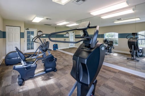 Fitness center with cardio equipment and large mirrors