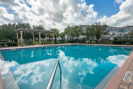 Swimming pool with lounge seating surrounded by native landscaping