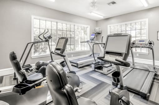 Fitness center with cardio machines, large windows and television
