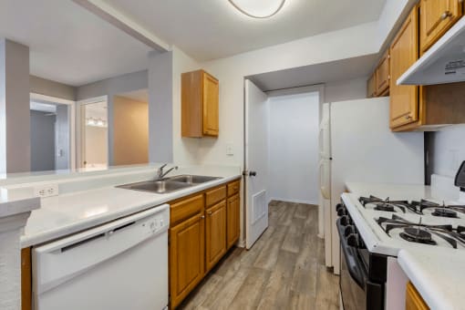 Kitchen with hardwood style flooring, double basin sink, white appliances, with gas stove range