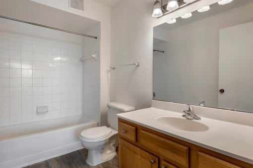 Bathroom with tiled shower and hardwood style flooring
