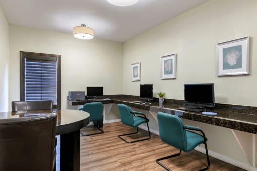 Business center with computers, desks, and hardwood style flooring