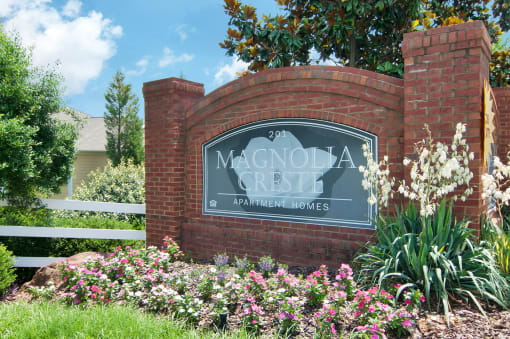 Community sign in the middle of a flower bed.