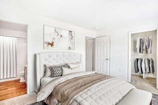 a bedroom with white walls and a white bed with a white tufted headboard