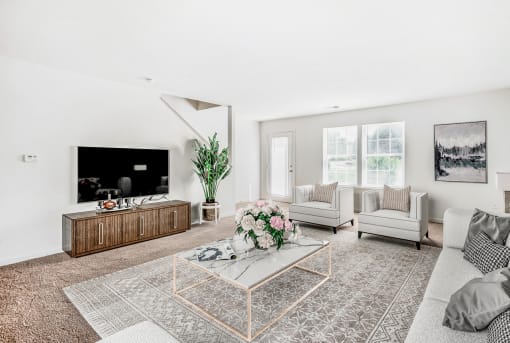 a living room with white walls and a large tv on the wall