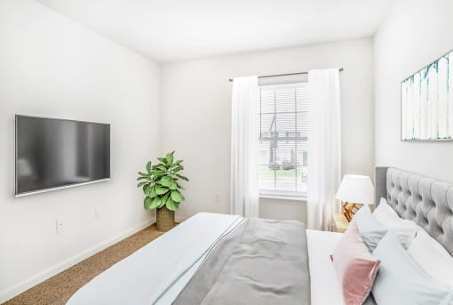 a bedroom with a large bed and a tv on the wall