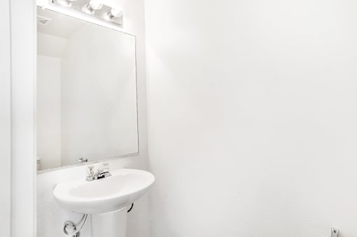 A white sink in a white bathroom.
