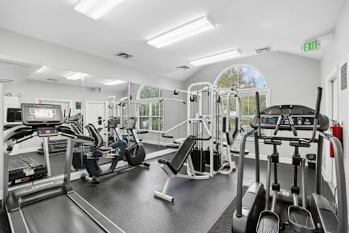 A gym with treadmills, elliptical machines, and other exercise equipment.