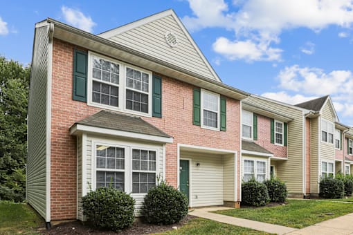 A row of houses with green shutters and white trim.