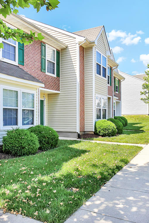 A row of houses with green bushes in front.