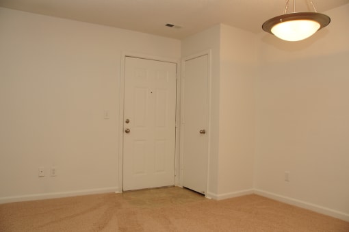 The entrance to the apartment has linoleum flooring and then wall to wall carpet. There is a coat closet just off the entry and overhead lighting in the dining room.