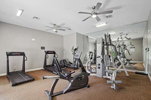 A spacious gym with treadmills, elliptical machines, and weight machines.