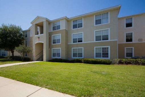 Building Exterior with Grassy Courtyard and Sidewalk with Tree