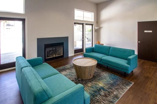 Interior leasing office seating area with two couches and fireplace