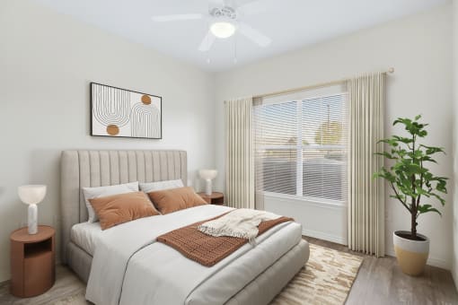 a bedroom with a large window and a ceiling fan