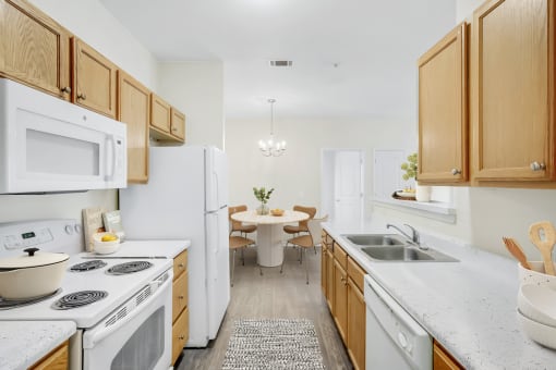 a kitchen with white appliances and wooden cabinets