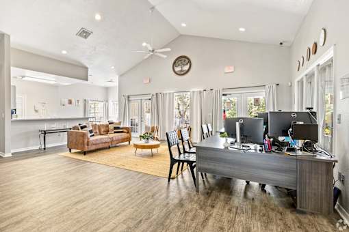 A spacious home office with a desk, chairs, and a computer setup.