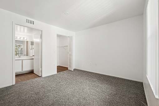 A room with a grey carpet and white walls.