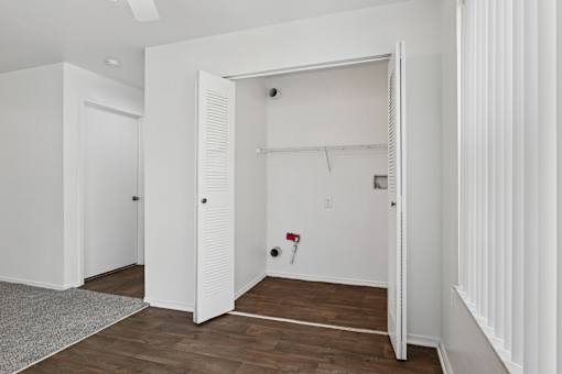 A white room with a door open to another room.
