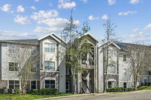 A large apartment complex with a mix of grey and white buildings.