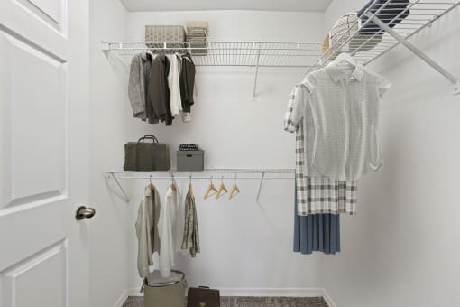 a small walk in closet with white walls and a white closet door with a white door and