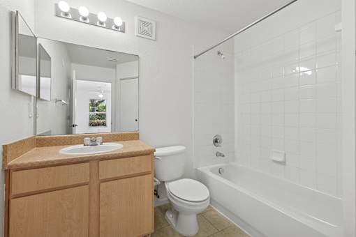 A white bathroom with a toilet, sink, and bathtub.