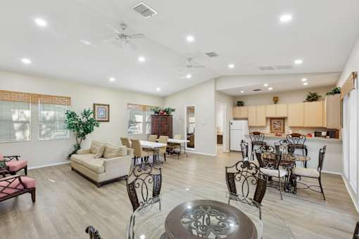 A living room with a dining area and kitchen in the background.