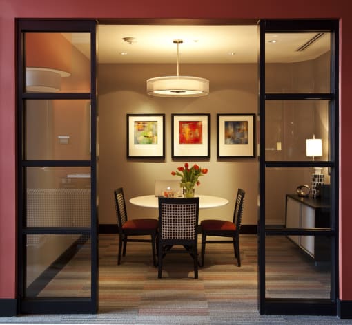 Conference room with a four top dining seating, orange accents, and carpet flooring.