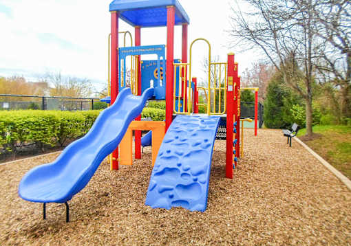 A playground with a blue slide and a red and yellow structure.