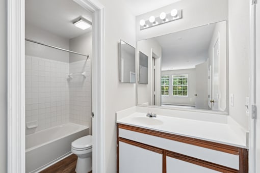 A white bathroom with a toilet, sink, and shower.