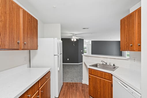 A kitchen with white appliances and wooden cabinets.