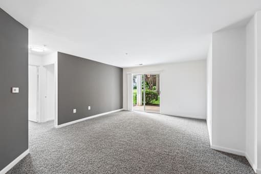 A room with grey carpet and white walls.
