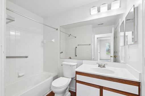 A white bathroom with a toilet, sink, and bathtub.
