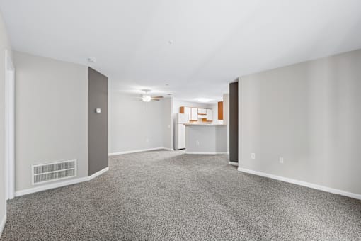 A living room with a carpeted floor and white walls.
