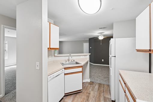A small kitchen with white appliances and wooden cabinets.