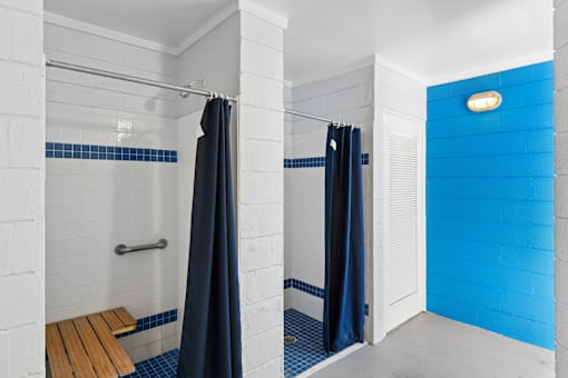 A bathroom with a blue wall and a white shower area.