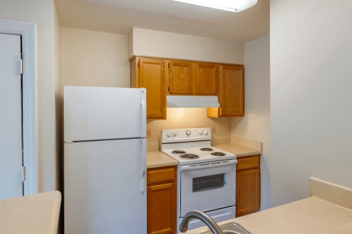 Kitchen with Blonde Cabinets Tan Counters and White Appliances