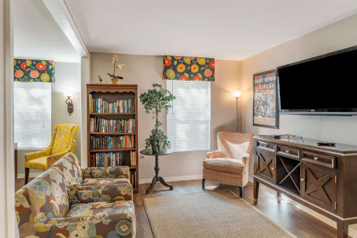 Model Living Room  with Couch, Bookshelf. Area Rug, Armchair and Entertainment Center Under Mounted TV