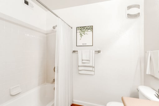 Virtually staged bathroom with tiled tub, shower curtain