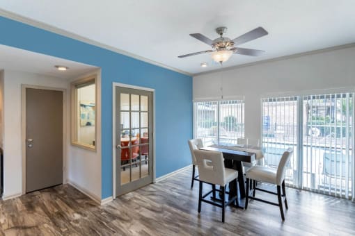 Clubhouse Interior with blue accent wall, ceiling fan, and hardwood style flooring