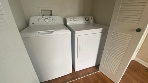 Laundry Room with double door folding doors and  full size side by side washer and dryer