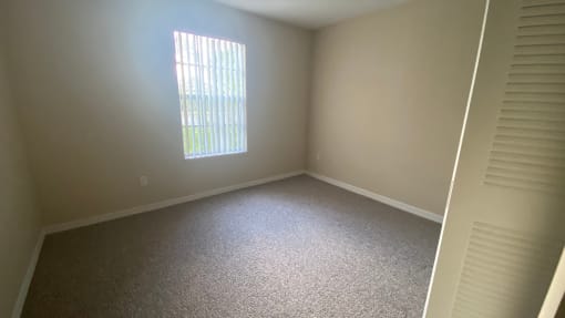 Carpeted Guest Bedroom with one window, and closet to the right of front door