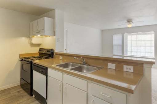 a kitchen with white cabinets and a stainless steel sink